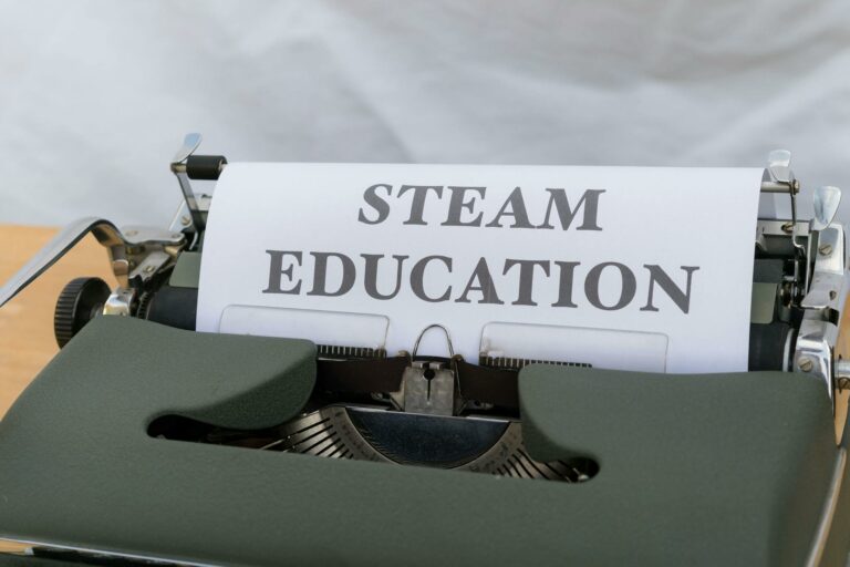 Close-up of a vintage typewriter displaying 'STEAM Education' on a sheet of paper. Ideal for educational content.