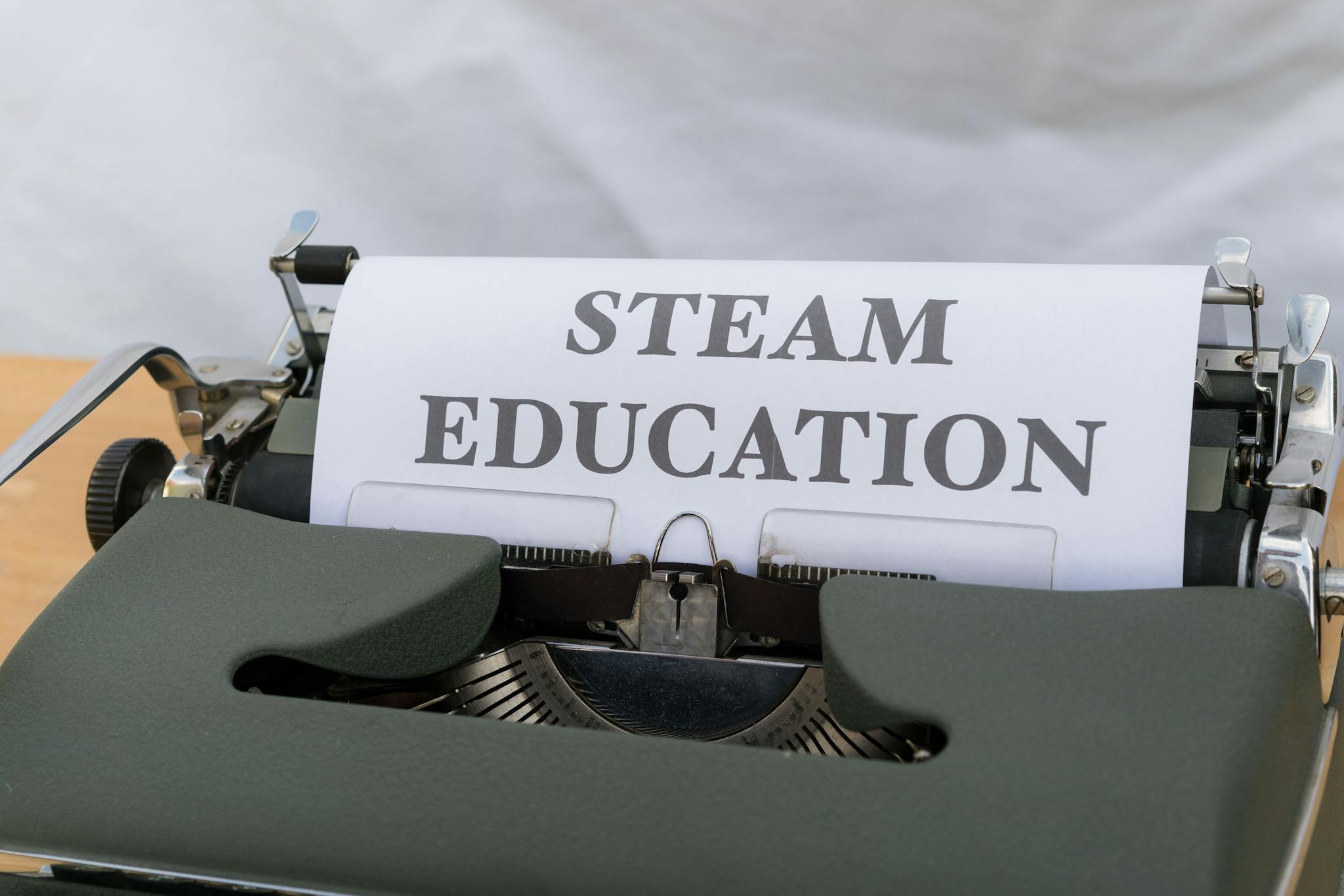 Close-up of a vintage typewriter displaying 'STEAM Education' on a sheet of paper. Ideal for educational content.